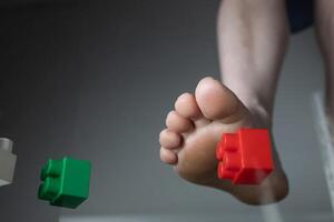 Foot Experiencing Pain Due to Stepping on Construction Toy Blocks in a Household Environment photo