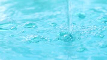 water, clear blue water with bubbles in motion, water surface, representing freshness, purity, and health. Ideal for themes of drinking water and nature video