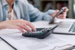 A person using a calculator on a desk photo