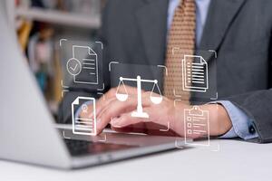 A man in a suit is typing on a laptop with icons on it photo