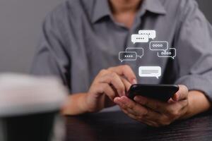 Man using smartphone with chat bubbles photo
