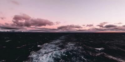 Ocean Waves Wake at Pink Sunset Mountains in Background photo