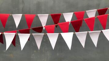 Red and white triangular bunting flags hang against a gray background, creating a festive and cheerful atmosphere., perfect for Indonesia independence day concept video