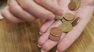 Close-up of a person counting Euro coins in their hand, emphasizing financial management, savings, and currency handling. video