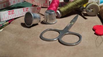 Close-up of Sewing Tools on Fabric Surface with Scissors, Threads, and Measuring Tape in Craft Workspace video