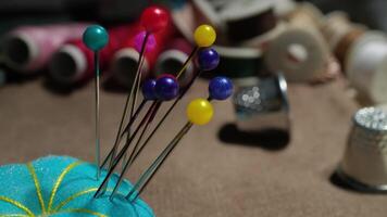 Colorful Sewing Pins Stuck in Blue Pin Cushion with Threads and Thimbles in Craft Workshop video