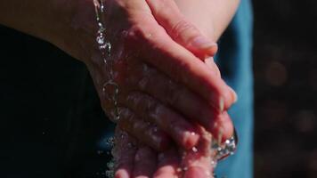 Close-up of Hands Gently Catching Fresh Water Flow in Natural Outdoor Setting with Soft Focus video