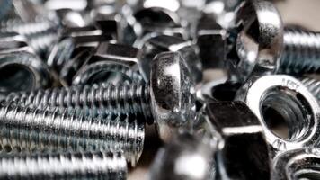 Macro shot of shiny metal bolts and nuts, highlighting the reflective surfaces and intricate details of the hardware. video