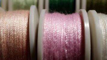 Close-up View of Colorful Sewing Threads on Spools in a Crafting Environment with Soft Lighting video