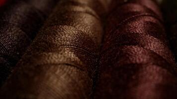 Close-up of textured colorful threads tightly wound in dim light environment showcasing textile details and vibrant fibers video