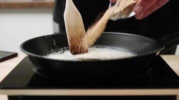 Close-Up of Sugar Being Caramelized in a Black Frying Pan on a Modern Stove in a Cozy Kitchen video