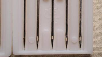 Close-Up Macro View of Sharp Metal Needles Neatly Arranged in White Plastic Holders for Sewing and Crafting video