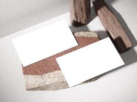 Minimalist business card placed on top of a stone with wooden logs in the background for a modern look. photo