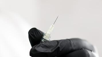 Open syringe needle for injection. Hands in medical gloves preparing a syringe before injection on a white background. Vaccination. Sterile medical products. photo