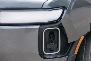Close-up of the charging port in an electric vehicle near the headlight. The details of the port are clearly visible, highlighting the modernity photo