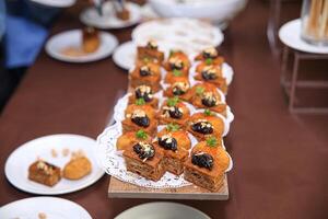 A table topped with small desserts and plates photo
