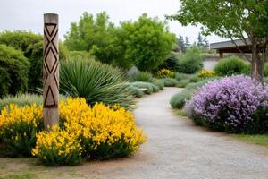 Gravel path winding through colorful botanical garden with carved wooden totem photo