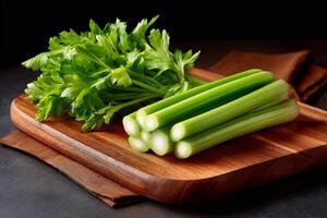 Fresh celery stalks and leaves resting on wooden cutting board photo
