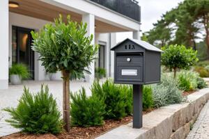 Modern mailbox standing in front of a beautiful house photo