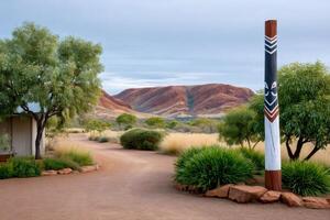 Gravel path leading to a cabin with aboriginal puti and the Hamersley Range in the background photo