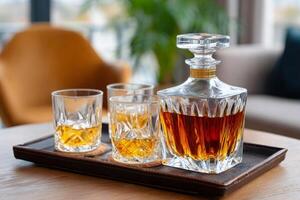 Crystal decanter and glasses with whiskey resting on elegant serving tray photo