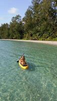 Aerial view of woman paddleboarding on crystal-clear turquoise water on lush tropical beach with palm trees on paradise island in Thailand. Concept of freedom, adventure, and summer travel. video