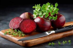 Fresh beetroots with leaves on wooden cutting board with knife and thyme photo