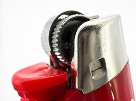 Red plastic lighter on a white background side view of the lighter in macro side view photo