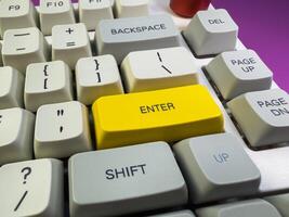 A close up of enter button mechanical keyboard with light grey, grey, yellow color keycaps photo