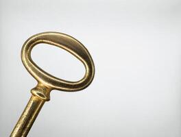 Golden metal key from an old chest on the left on a white background macro top view photo