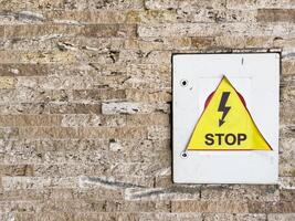 beware of electrical hazards, dangerous electrical voltage on a yellow isolated warning sign with empty advertising space. photo