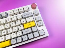 White and gray keyboard for programmer, on a purple background with a red button photo