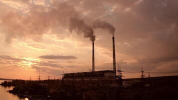 Industrial zone with thick smog from pipes. Factory zone pollutes the atmosphere. Factory chimneys with dirty emissions on the evening sky background. Camera rising. video