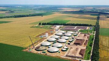 Biogas plant. Farm for renewable energy from biomass. Modern agriculture on field. Aerial view. video