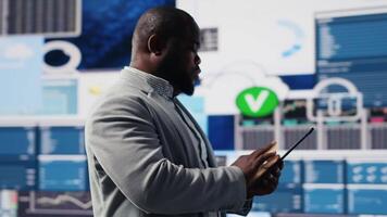 African american businessman in a digital environment focused on graphs, working on strategic planning analysis for profitability and performance. Insightfulness and fintech forecasting. Camera B. video