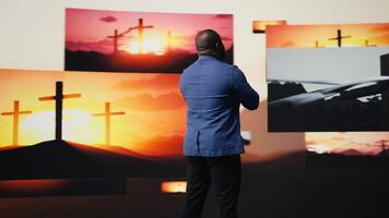 Devoted male worshipper praying in silence embodying serenity and inner peace. Surrounded by sacred crosses, represents a mindful connection to Jesus, inspiration and spirituality. Camera A. video