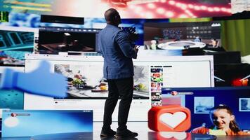 Young black person showcasing visual representation of online connection, immersed in web platforms and apps. Mobile technology surrounded by social network icons in a digital space. Camera A. video