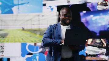 Black social media manager browsing high tech environment with app interfaces, infographics and social networking feeds. Big data on social media platforms, multimedia. Camera B. video