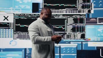 Young business leader checking online fintech reports on mobile phone, examining infographics for financial insight and development. Young adult browses smartphone apps. Camera A. video