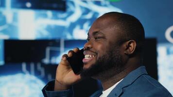 Tech entrepreneur talking on a phone call in an AI environment, representing predictive algorithms and deep learning platforms. Working on automation and intelligent cybernetics. Camera B. video