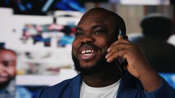 Black relaxed person taking a smartphone call from friends, emphasizing modern networking connection and human interaction through social media apps. Online communication. Camera B. video