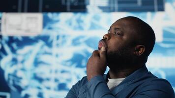 African American IT specialist examining artificial intelligence interface, showcasing machine learning algorithms through devices. High tech neural networks and data structures. Camera B. video