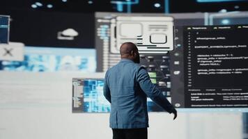 Preto profissional Programas engenheiro programação para tecnologia inovação, revendo dados e binário código em a painel. isto especialista examinando programação língua para transformação. Câmera uma. video
