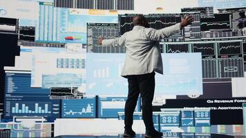 Black executive manager thinks about a new strategy to increase the company profit while he reviews infographics and fintech big data with digital tools. Startup development. Camera A. video