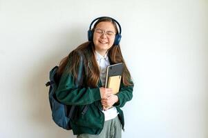Smiling teenage student holding a book, standing against a clean white background, ready for school or study. photo
