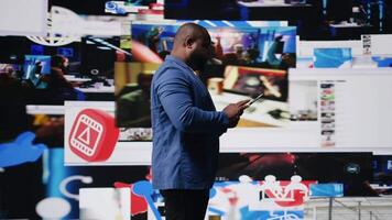 Young black person connecting to global social networks apps through mobile devices, opening platforms online on the dashboard. Communication and multitasking on social media. Camera A. video