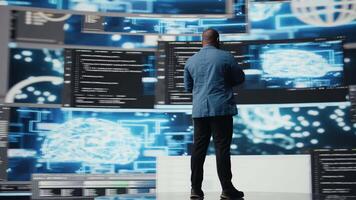 africano americano especializado engenheiro programação para inovação eixo, revendo grande dados e binário código em a painel. isto desenvolvedor trabalhando em programação língua algoritmo. Câmera uma. video