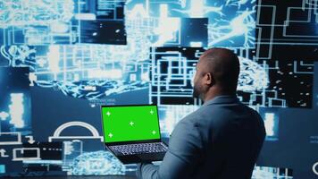 Young entrepreneur technician using advanced technology and green screen on laptop, exploring data science, automation and AI brain in a digital data visualization. Machine learning. Camera A. video