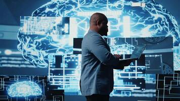 Digital concept of African American engineer exploring artificial intelligence, showcasing deep learning algorithms, high tech neural networks and futuristic data structures. Camera A. video