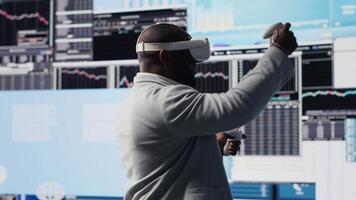 High tech startup entrepreneur using virtual reality glasses to examine KPI models, reviewing infographics and working on business productivity. Professional VR gadget simulation. Camera B. video